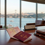 Turkish passport on attorney's desk with Bosphorus view — Turkish citizenship by investment by Oznur & Partners